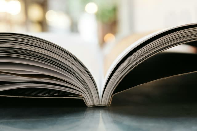 An open book lying flat, its pages fanned